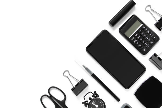 istock Collection of office accessories in black on white background with copy space. Smartphone, calculator, alarm clock, scissors, lipstick, watches. Top view. Business flat lay. 1316005205