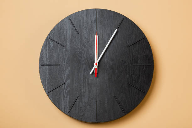 istock minimalist black wall clocks on brown background 1316005688