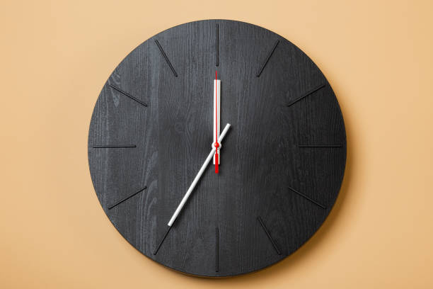 istock minimalist black wall clocks on brown background 1316005707