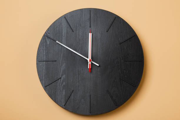 istock minimalist black wall clocks on brown background 1316005718