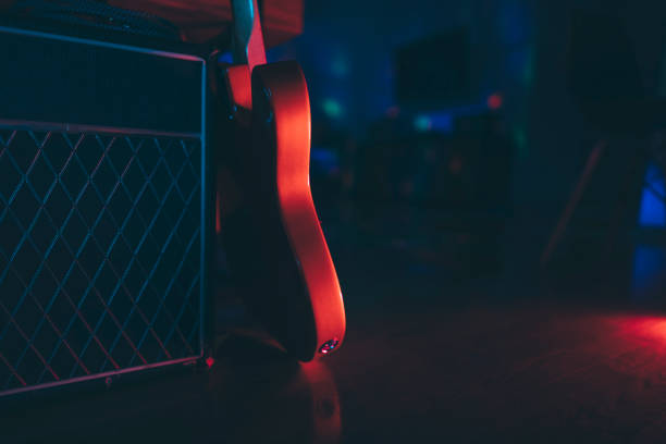 Electric guitar and classic amplifier Electric guitar body silhouette  and classic amplifier in nightclub, copy space. microphone stand stock pictures, royalty-free photos & images