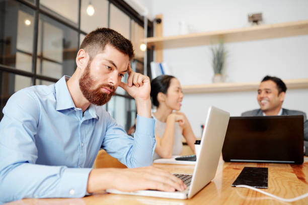 istock Tired businessman working on laptop 1316007625