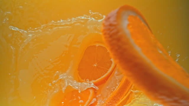 SLO MO Orange slices falling into a juice