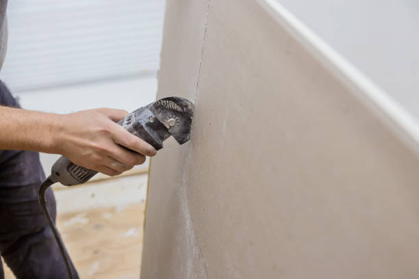 istock Man cutting gypsum drywall on using angle hand electric power tools 1316012859