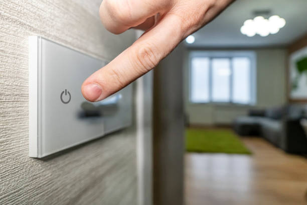 istock close-up finger turns on the light on the touch switch. A white modern light switch on a white wall. modern design. 1316013266