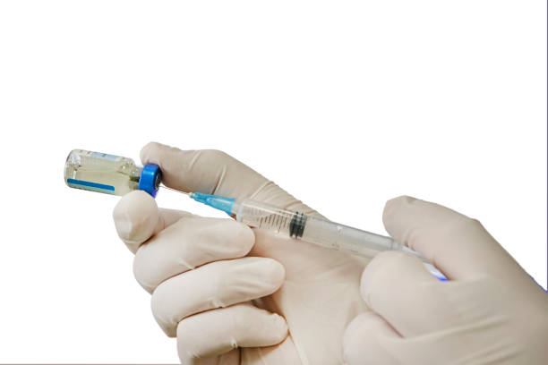 istock doctor draws medicine solution into syringe from vial on white background. doctor hands and ampoule isolated on white. 1316013316