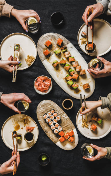 plat-lay des personnes mangeant divers sushi pendant le dîner japonais de verrouillage - susi photos et images de collection