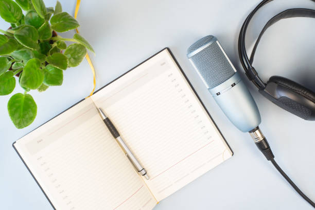 istock Podcast concept. Studio microphone, headphones and open notebook on light background indoors, flat lay. Professional broadcasting equipment. 1316019661