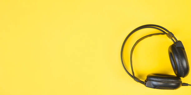 istock Black studio headphones on a yellow background. Banner with place for text. Flat lay, copy space. 1316019668