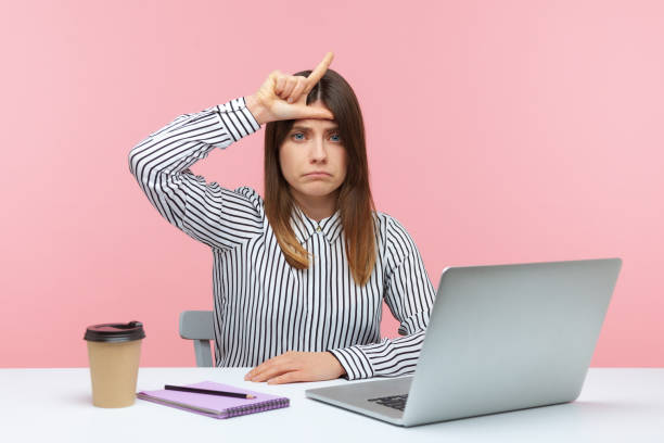 istock Upset woman office worker showing loser gesture sitting at workplace looking at camera with depressed expression, unhappy with lost job 1316021820