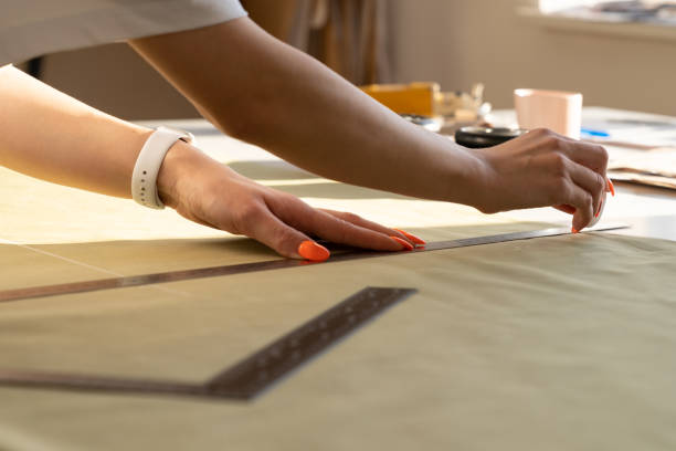 istock Creating trendy clothes: closeup of female designer work on draft, fabric on sewing table in studio 1316021984