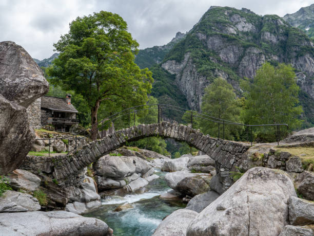 Ticino roman bridge and clear water river, Ticino canton, Switzerland High mountains in distance, sunlight. lepontine alps stock pictures, royalty-free photos & images