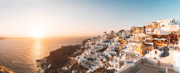 Panorama of Oia at sunset - Santorini Panoramic photo of Oia town at sunet. fira santorini stock pictures, royalty-free photos & images