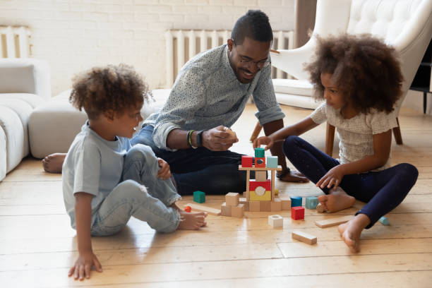 istock Happy daddy and two engaged preschooler kids building tower 1316025645