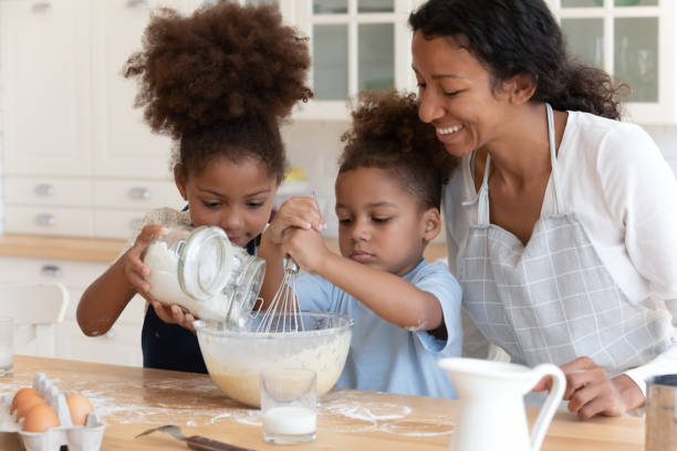 istock Happy mom teaching two preschooler kids to bake pie 1316025689