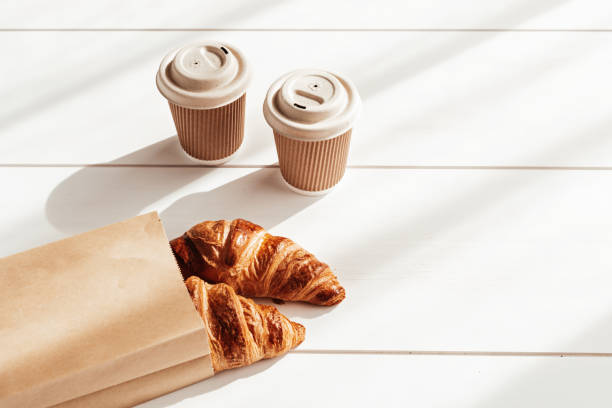 istock Hot coffee on the go and croissants for breakfast. Biodegradable, disposable takeaway cups 1316029539