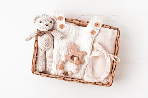 Cesta de regalo con prenda y accesorios para bebés neutros de género. Caja de cuidado de ropa orgánica de algodón recién nacido photo