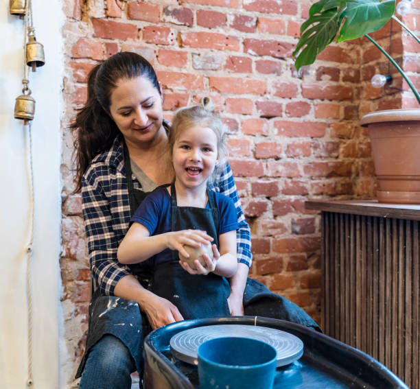 istock Young mom and her little daughter learning pottery on a pottery wheel. 1316031204
