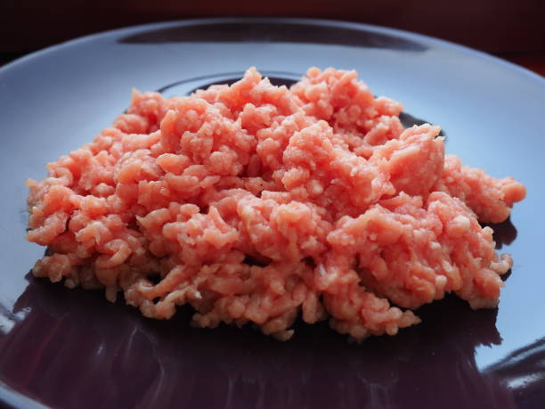 istock Minced meat on a purple ceramic large plate. Delicious fresh ground meat for making cutlets, steaks, hamburgers, meatballs. Pork semi-finished products 1316031584