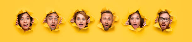 istock Surprised young people looking through ripped paper 1316031620