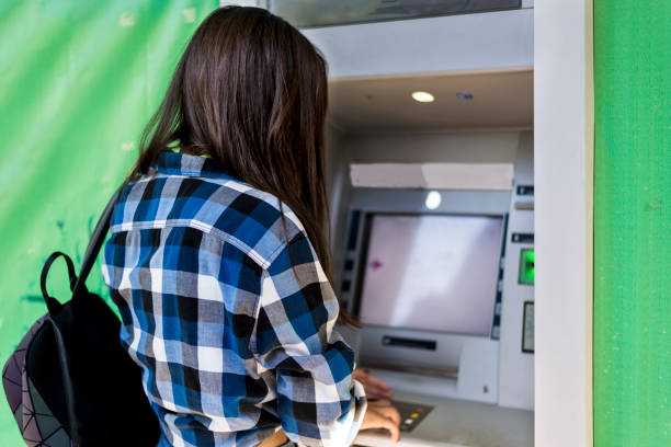 istock A young woman in front of an ATM 1316032361