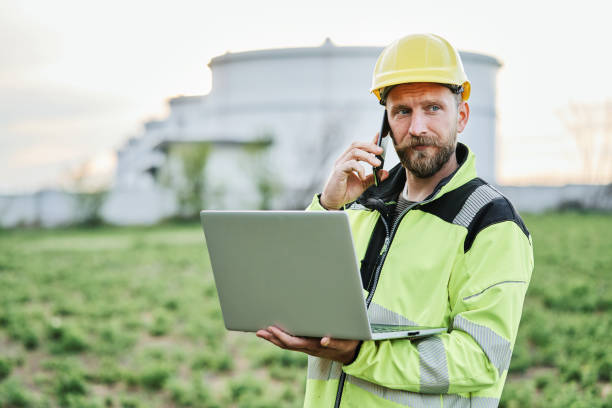 istock Refinery worker talking on a mobile phone in front of oil refinery 1316032423