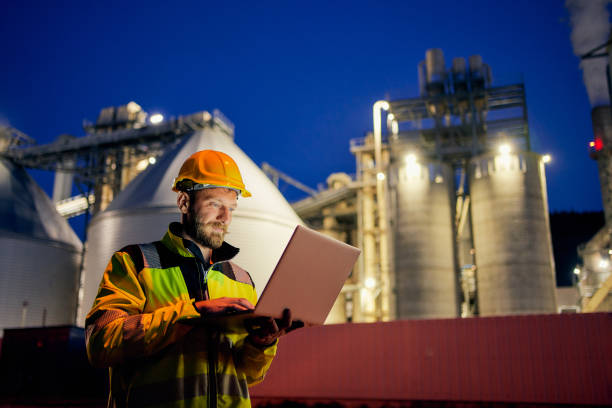istock Worker with safety helmet and laptop working in factory during night shift 1316032434