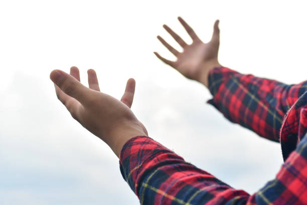 istock Hands of human praying on blue sky background 1316033199