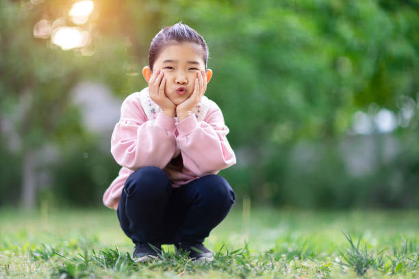 istock Cute Girl Squatting on the Grass 1316034322