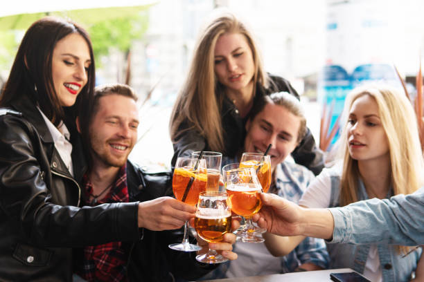 istock Friends celebrating and holding glasses with different alcohol drinks in a bar. 1316034649