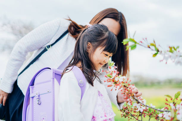 A girl and her mother going to the entrance ceremon A girl and her mother going to the entrance ceremon holding child flower april stock pictures, royalty-free photos & images