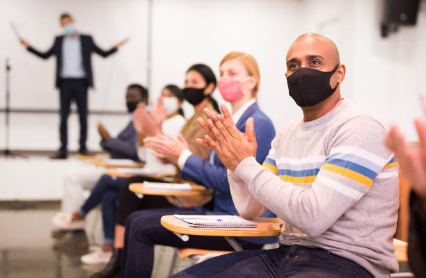 istock Man in mask applauding speaker at conference 1316041736
