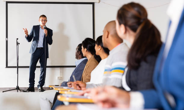 istock Confident man with microphone speaking at corporate business event 1316041893