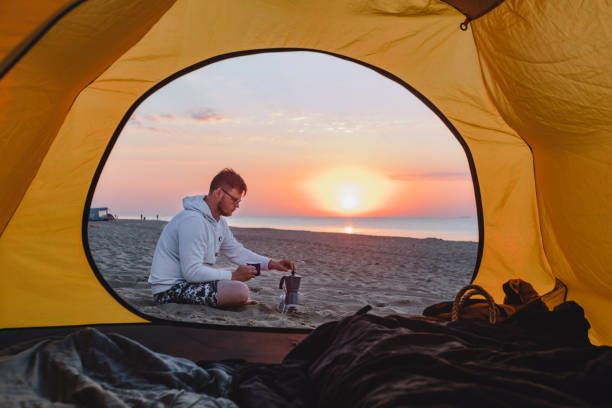 istock man cooking coffee at sea sandy beach. summer camping vacation 1316042521