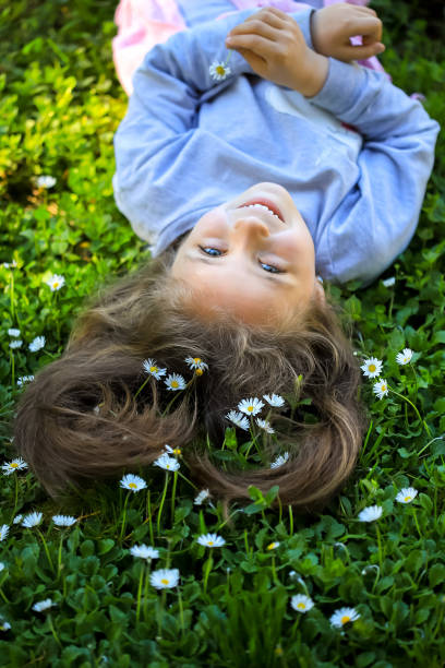 istock A girl lying on the grass with daisies 1316043857