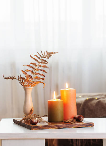 istock burning candles with autumn decor on white table at home 1316044486