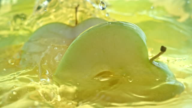 SLO MO LD Apple slices falling into juice