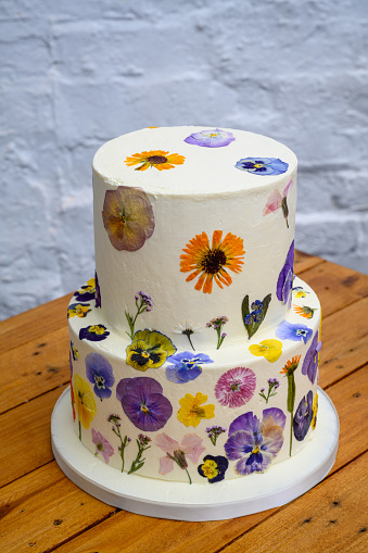 Colourful two tier wedding cake with fresh pressed flowers