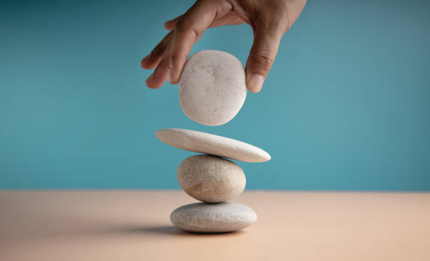 istock Life Balance Concept. Hand Setting White Natural Zen Stone Stack. Balancing Mind, Soul and Spirit. Mental Meditation Practice 1316054247