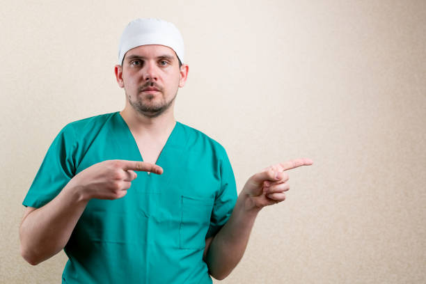 istock The doctor in a mask and glasses points to the side. 1316058491