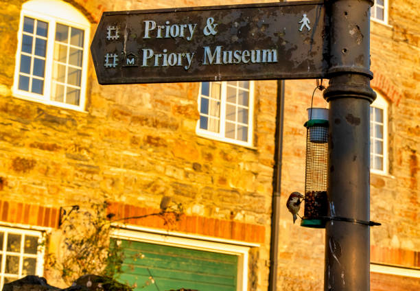 Sign pointing the way Sign pointing the way to Lindisfarne Priory and museum above a bird feeder on the Holy Island of Lindisfarne lindisfarne monastery stock pictures, royalty-free photos & images