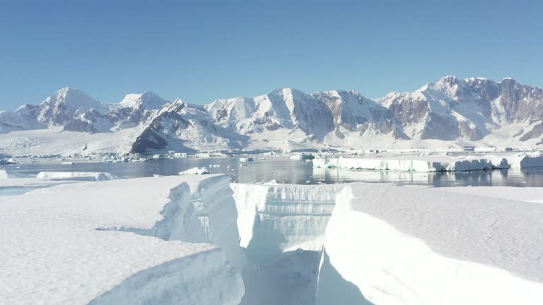 4K Aerial Landscape of snowy mountains and icy shores in Antarctica