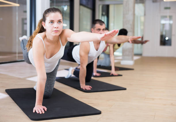 istock Young woman doing pilates workout with group at gym 1316063811