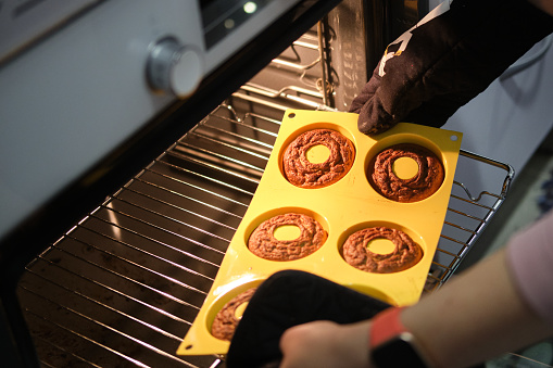 Homemade donuts cooking in their mold in the oven.