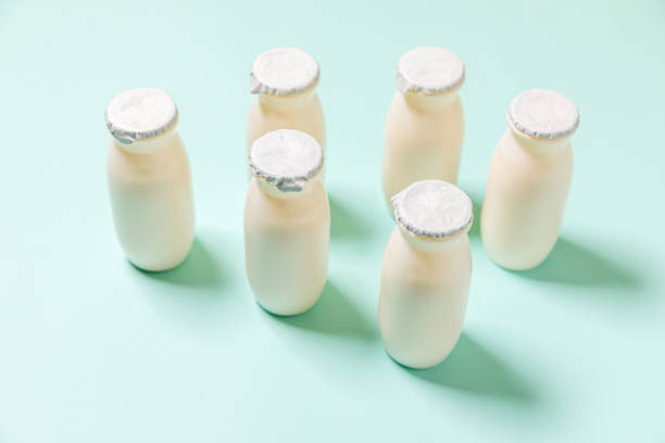 istock Small bottles with probiotics and prebiotics dairy drink on blue background. Production with biologically active additives. Fermentation and diet healthy food. Bio yogurt with useful microorganisms 1316065597