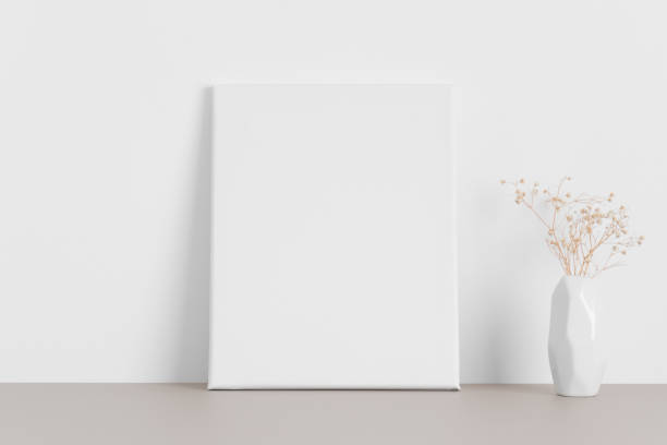 istock White canvas mockup with a gypsophila on the beige table. 1316066160