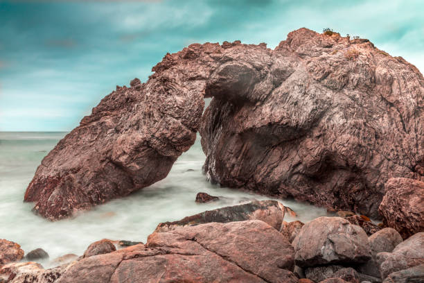 natürlicher bogenfelsen an der küste des big sur, kalifornien - coastline big sur california pacific ocean stock-fotos und bilder