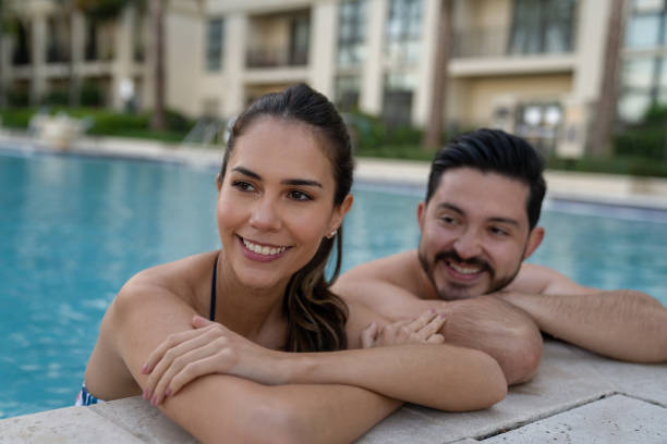 feliz pareja disfrutando del verano relajándose en la piscina - tourist resort apartment swimming pool caribbean fotografías e imágenes de stock