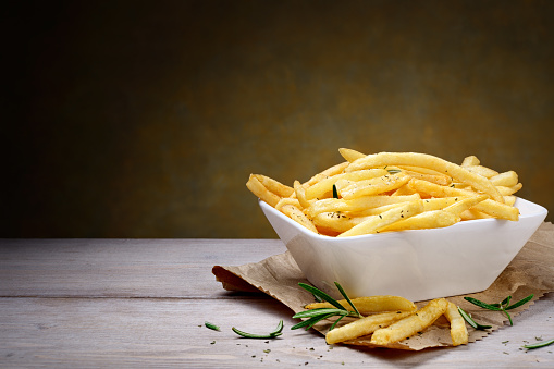 Homemade potato chips in ceramic bowl.