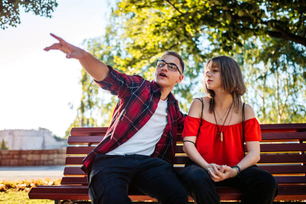 istock Teenage couple siting on park bench 1316071693